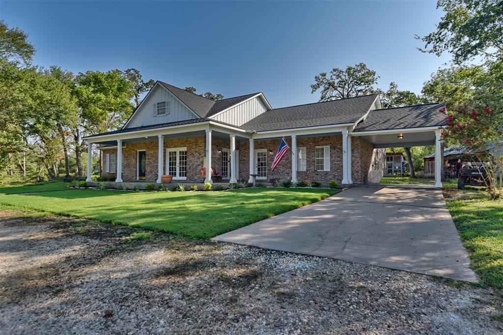 a front view of a house with a yard and potted plants