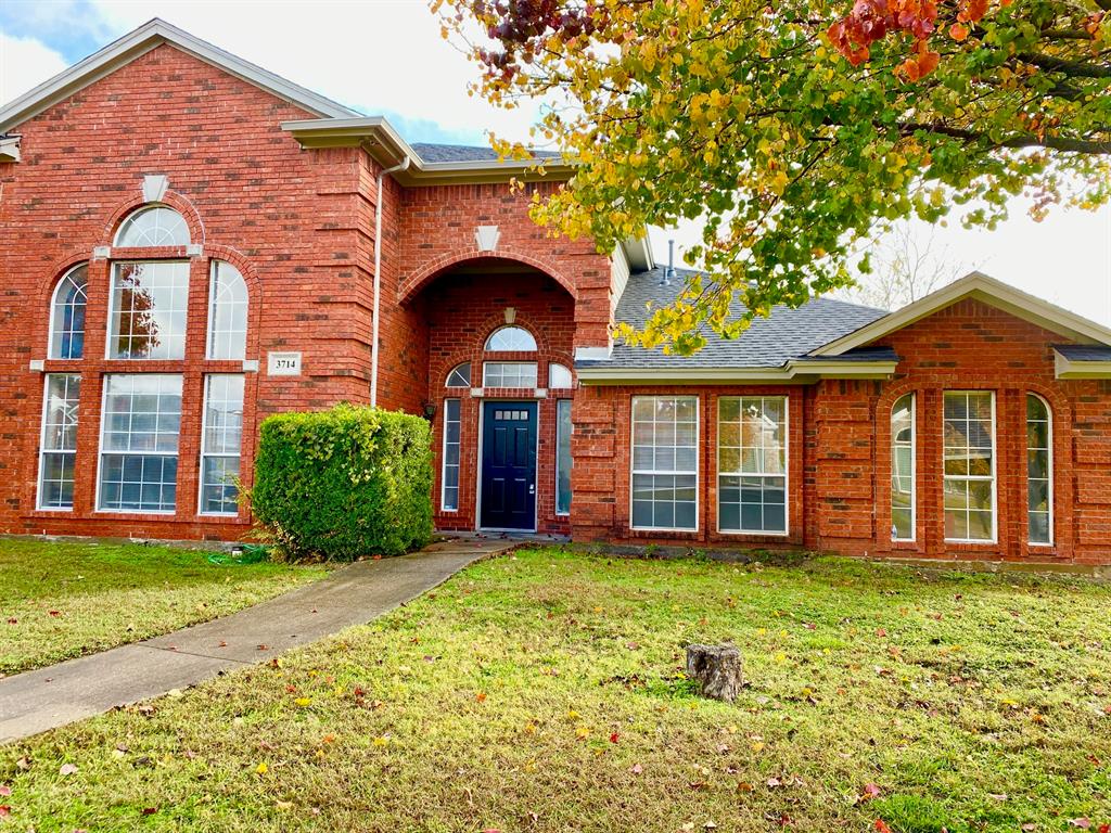 a view of a brick house with a yard