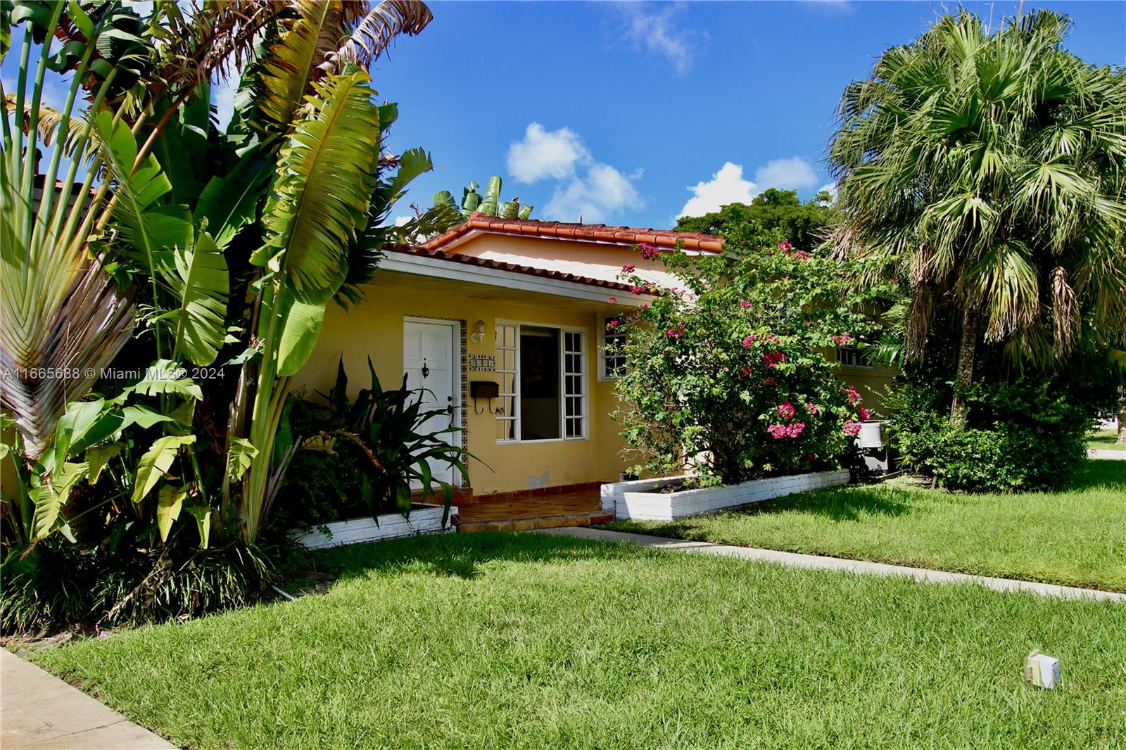 a view of a house with a yard and a garden