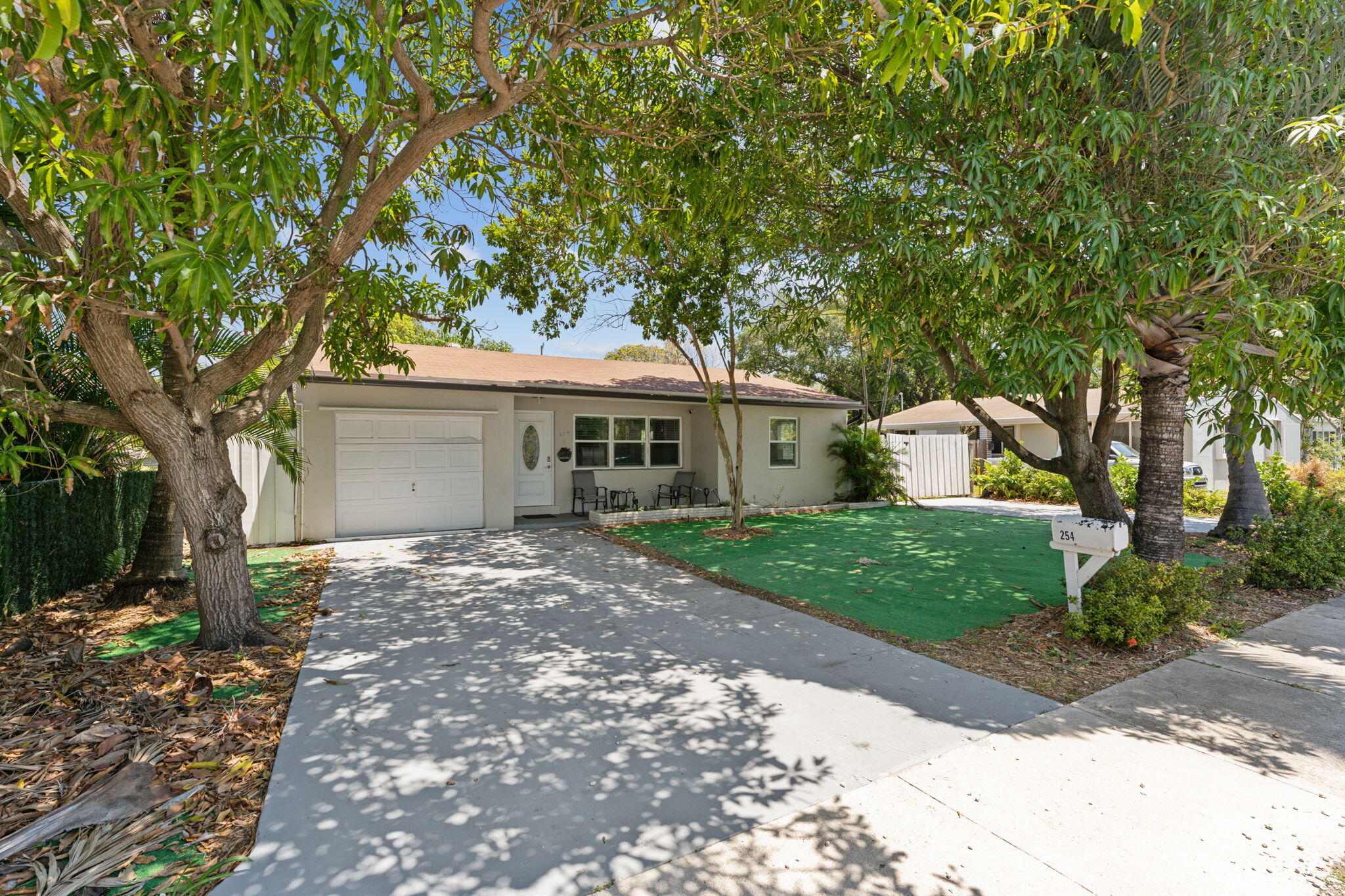 a front view of a house with a garden and trees