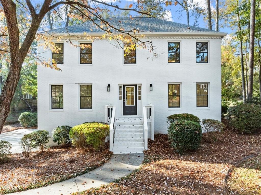 a view of a white house next to a yard