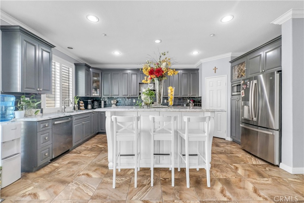 a kitchen with stainless steel appliances kitchen island granite countertop a refrigerator and a stove top oven