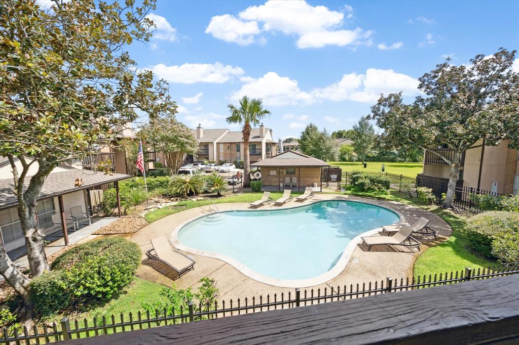 a view of a swimming pool with a patio and a yard