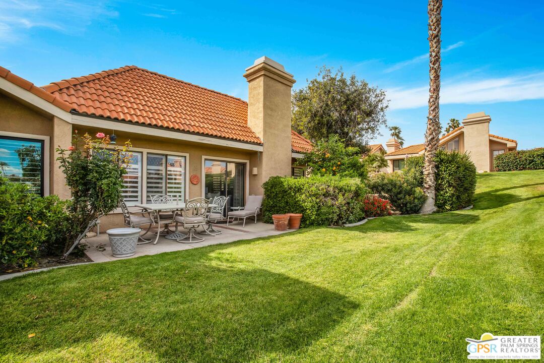 a view of a house with backyard and sitting area