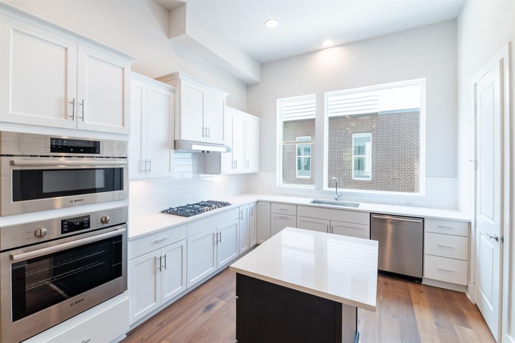 a kitchen with stainless steel appliances white cabinets and stove top oven