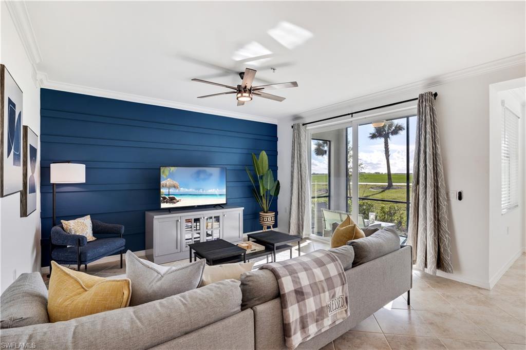 Tiled living room with crown molding and ceiling fan