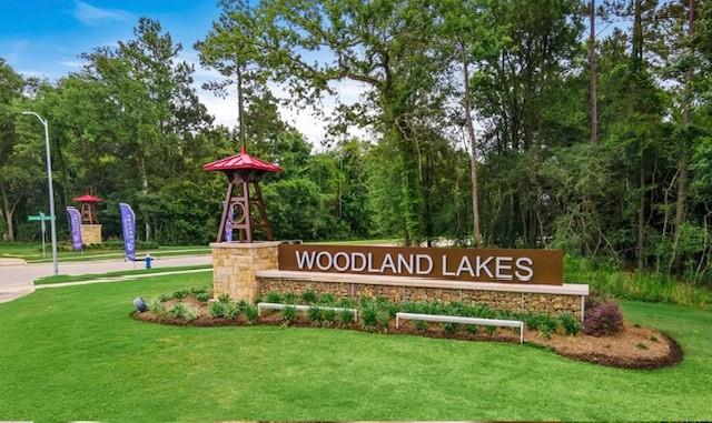 a view of a park that has a sign board large trees