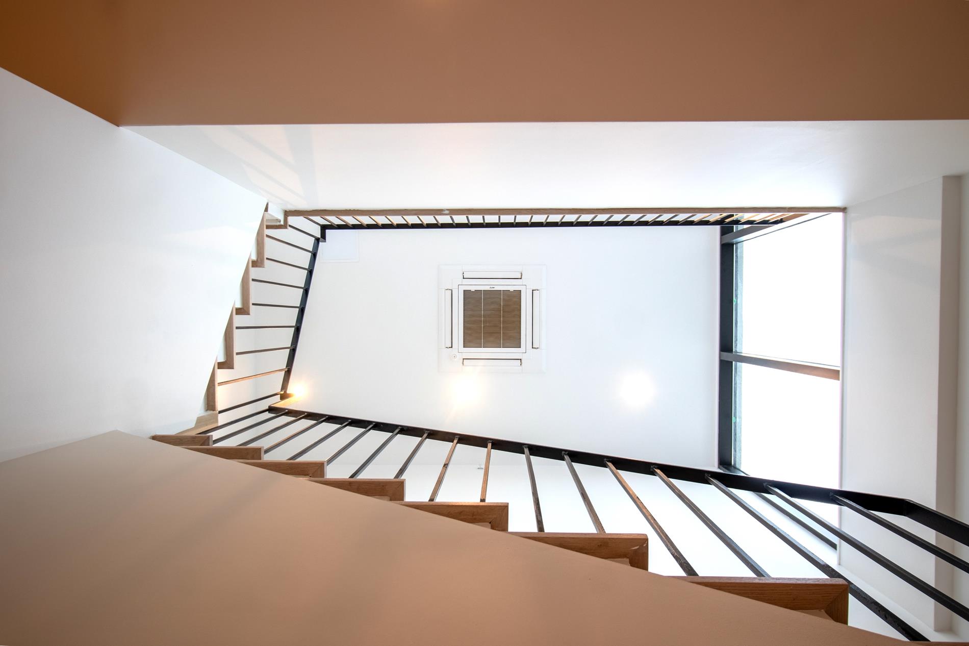 a view of staircase with white walls and a window