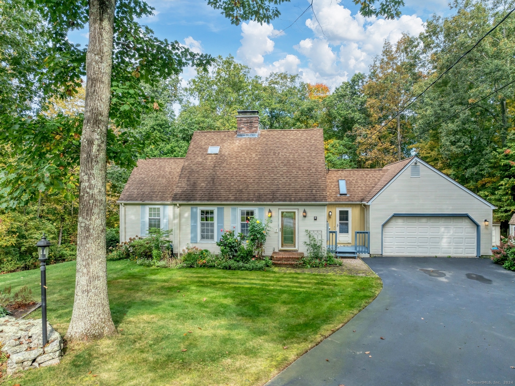 a front view of a house with a garden and plants