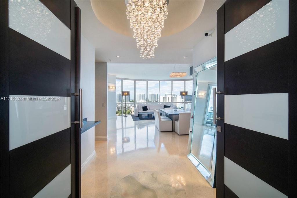 a living room with furniture a chandelier and a flat screen tv