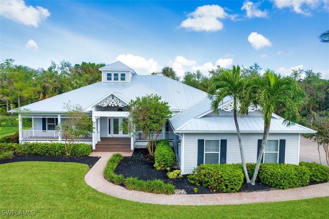 a front view of a house with a yard and potted plants