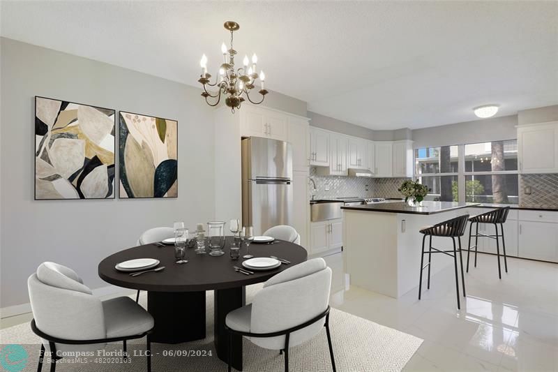 a kitchen with stainless steel appliances kitchen island a table and chairs in it