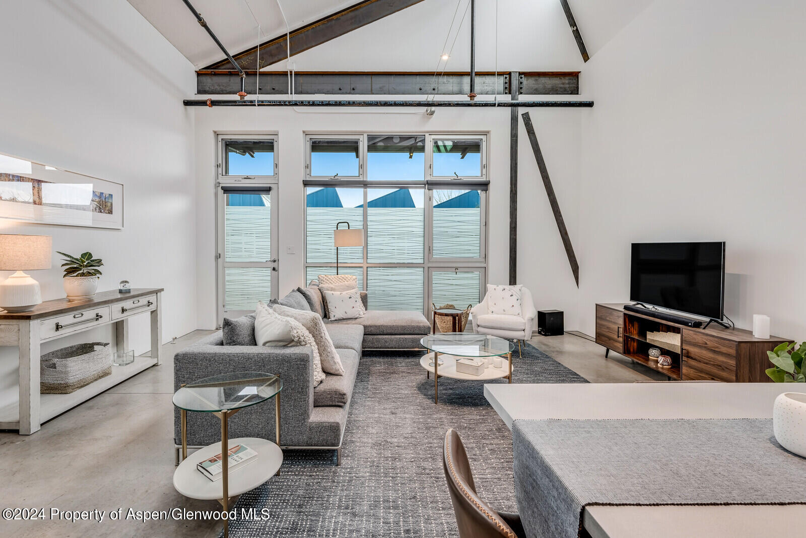 a living room with furniture a flat screen tv and a window