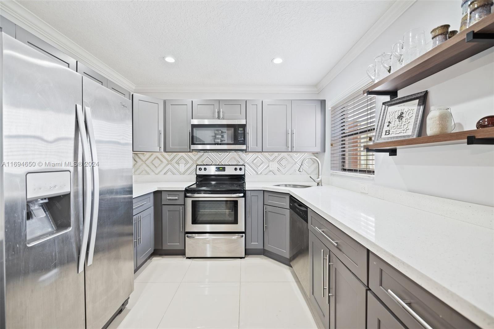 a kitchen with a sink a refrigerator and a microwave