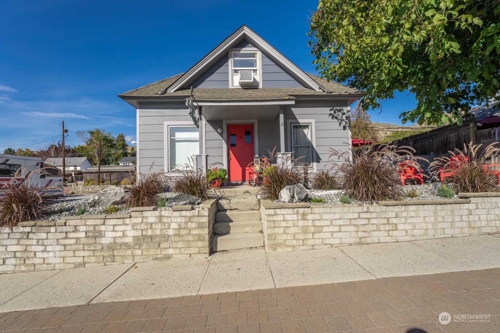 a front view of a house with lots of flowers