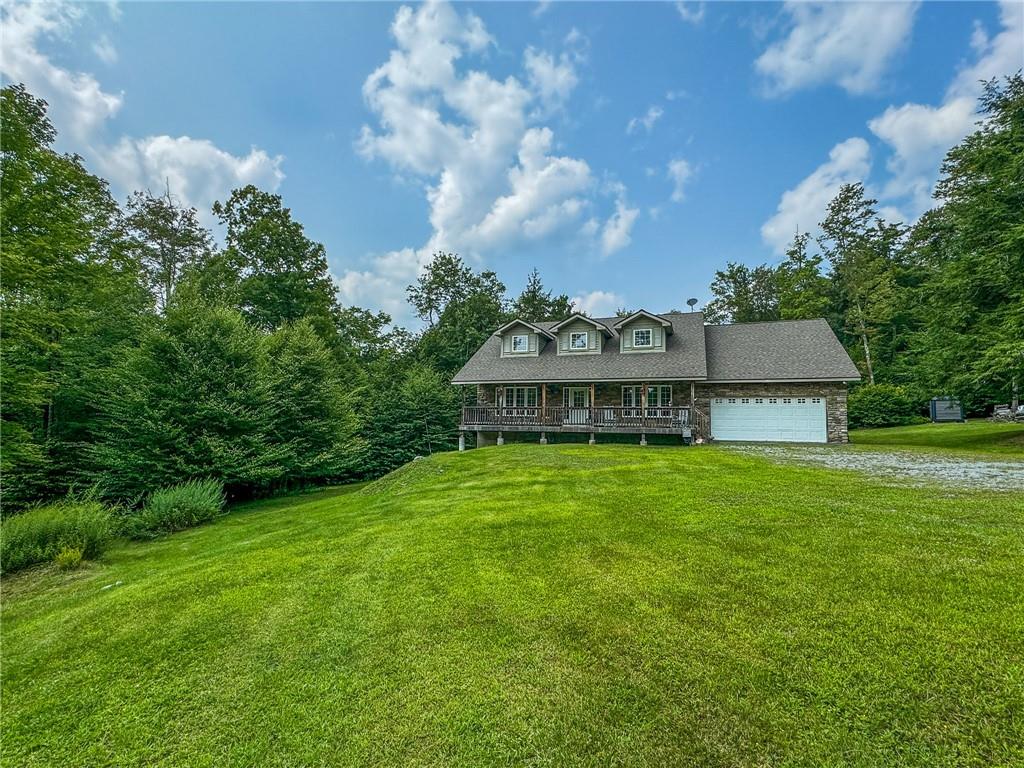 View of front of property with a front yard and a garage