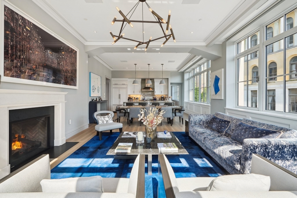 a living room with furniture a chandelier and a fireplace