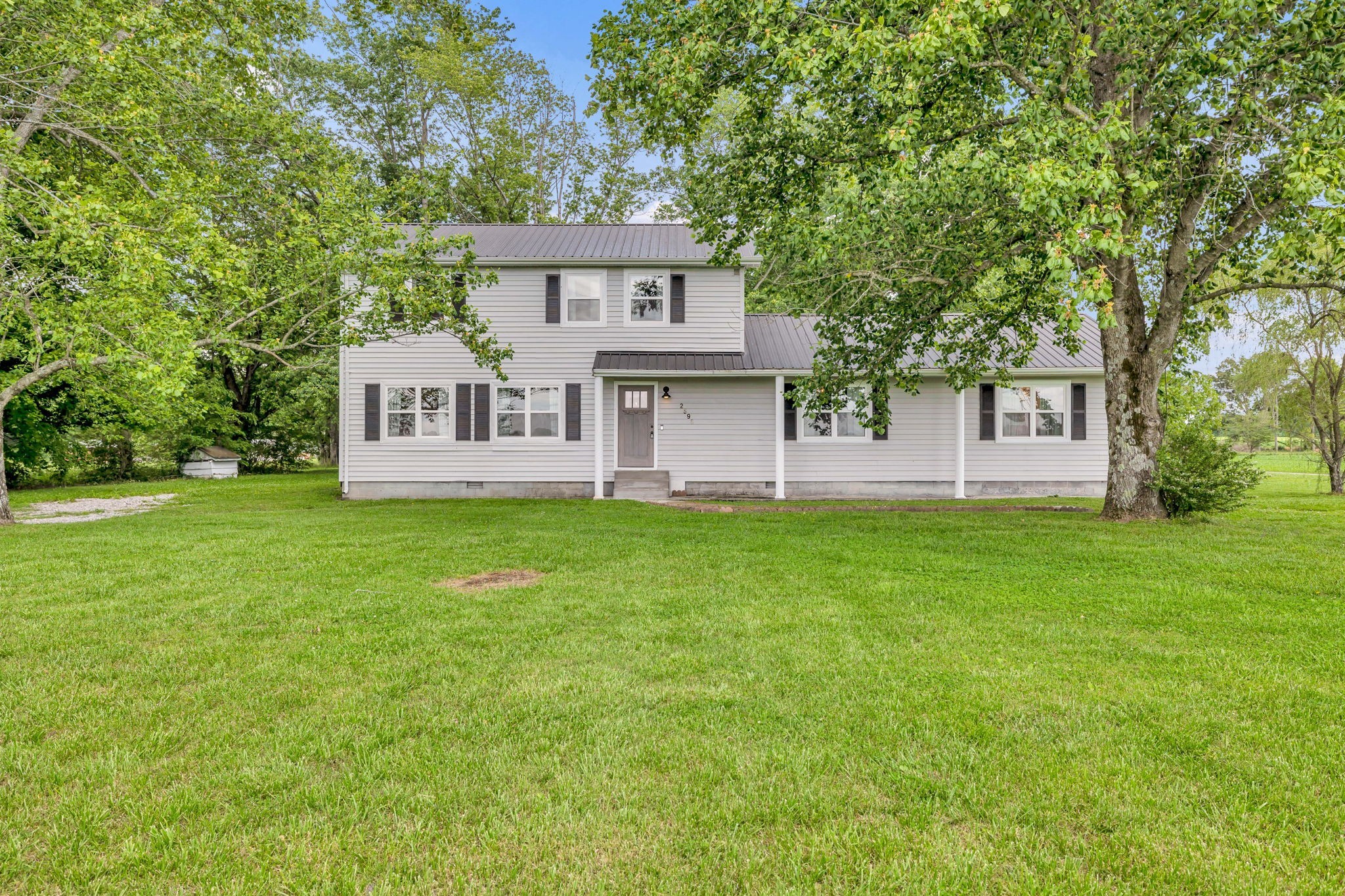 a front view of a house with a garden and yard