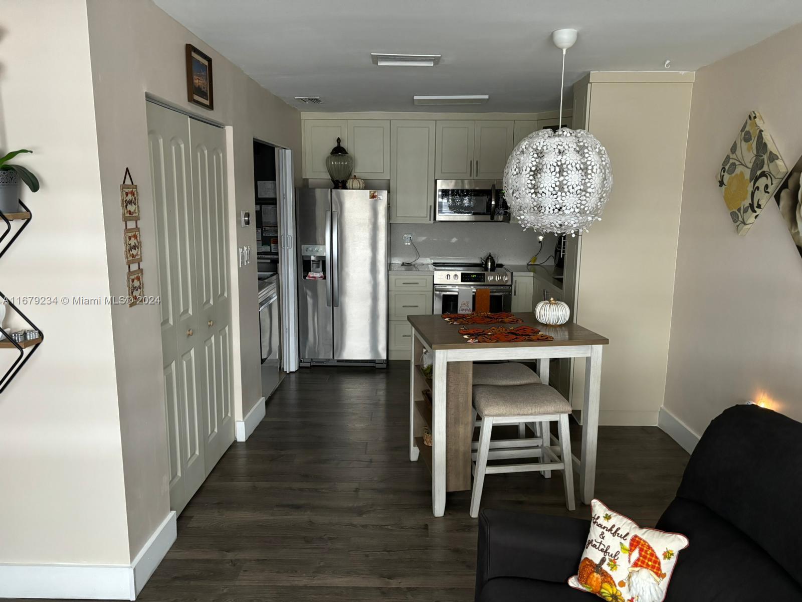 a kitchen with stainless steel appliances a table chairs and a chandelier