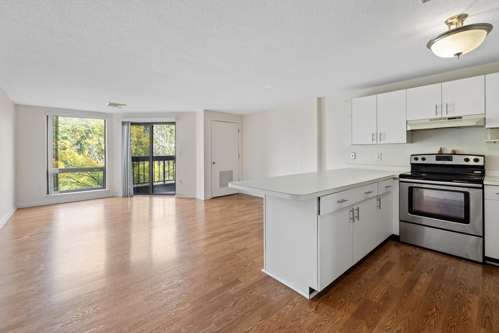 a kitchen with granite countertop a stove top oven sink and cabinets