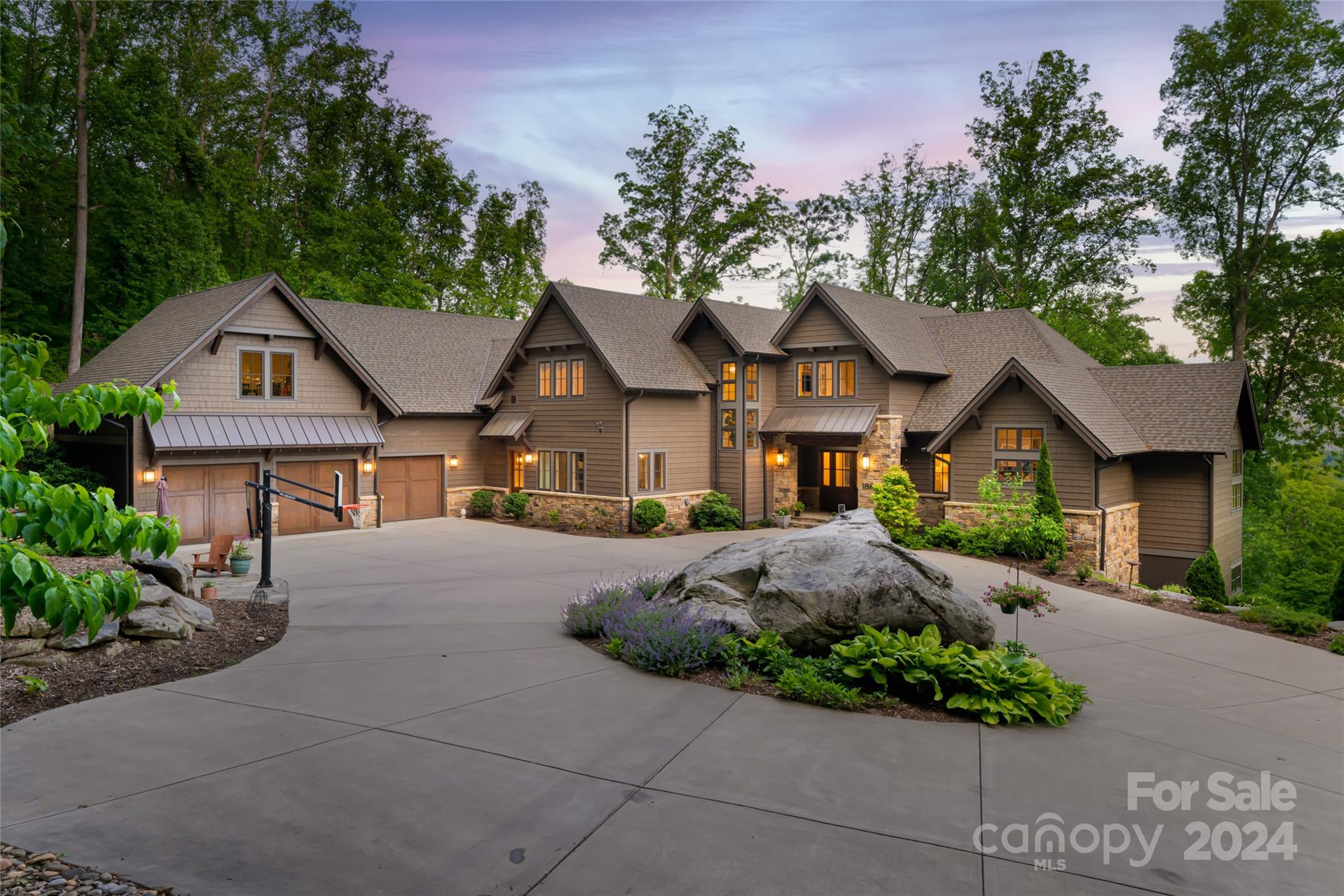 a front view of a house with a garden and trees