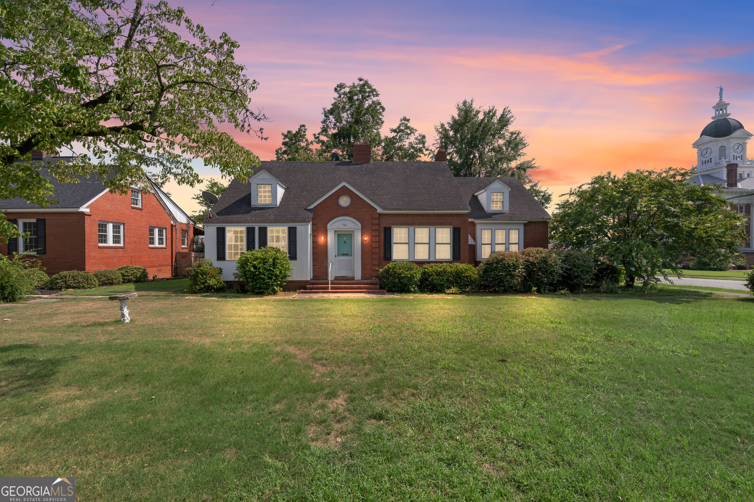 a front view of a house with a garden