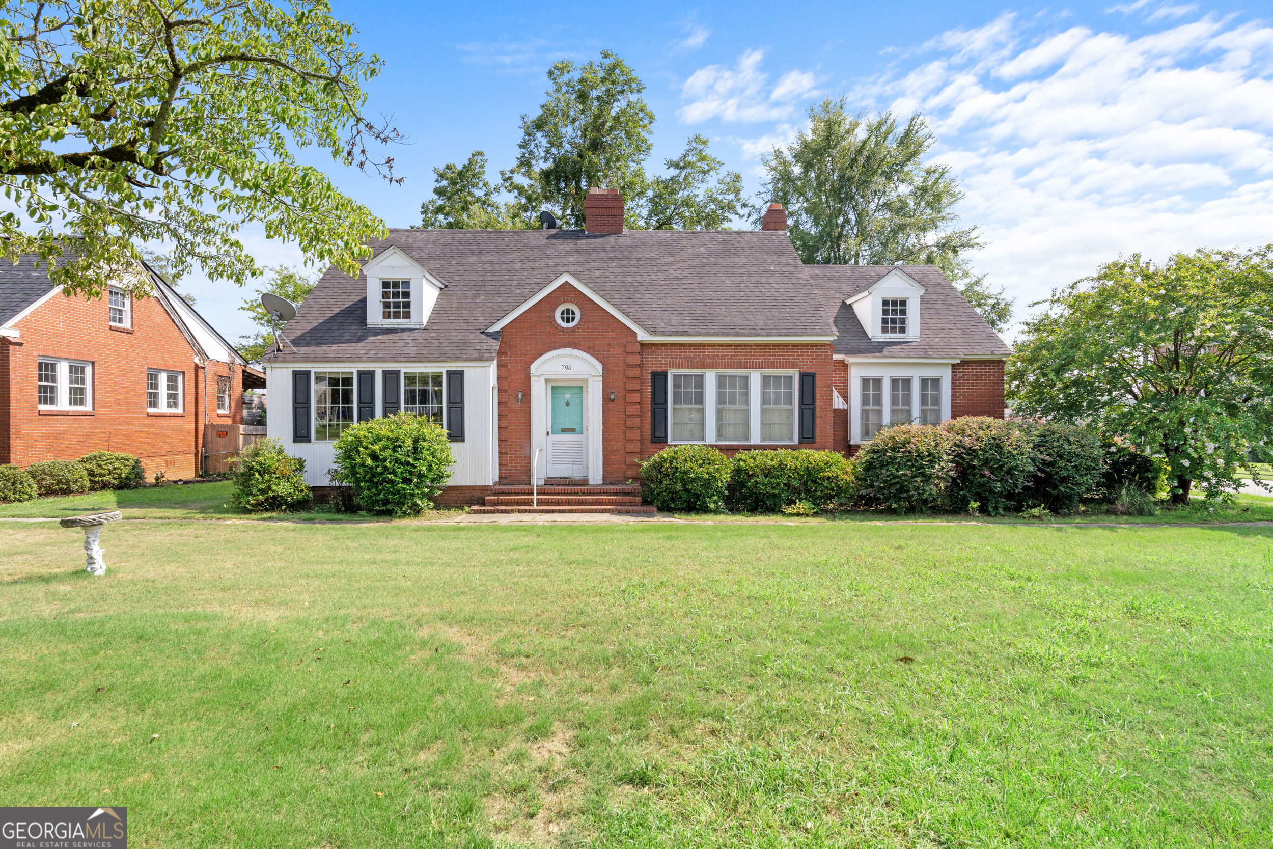 a front view of a house with a garden