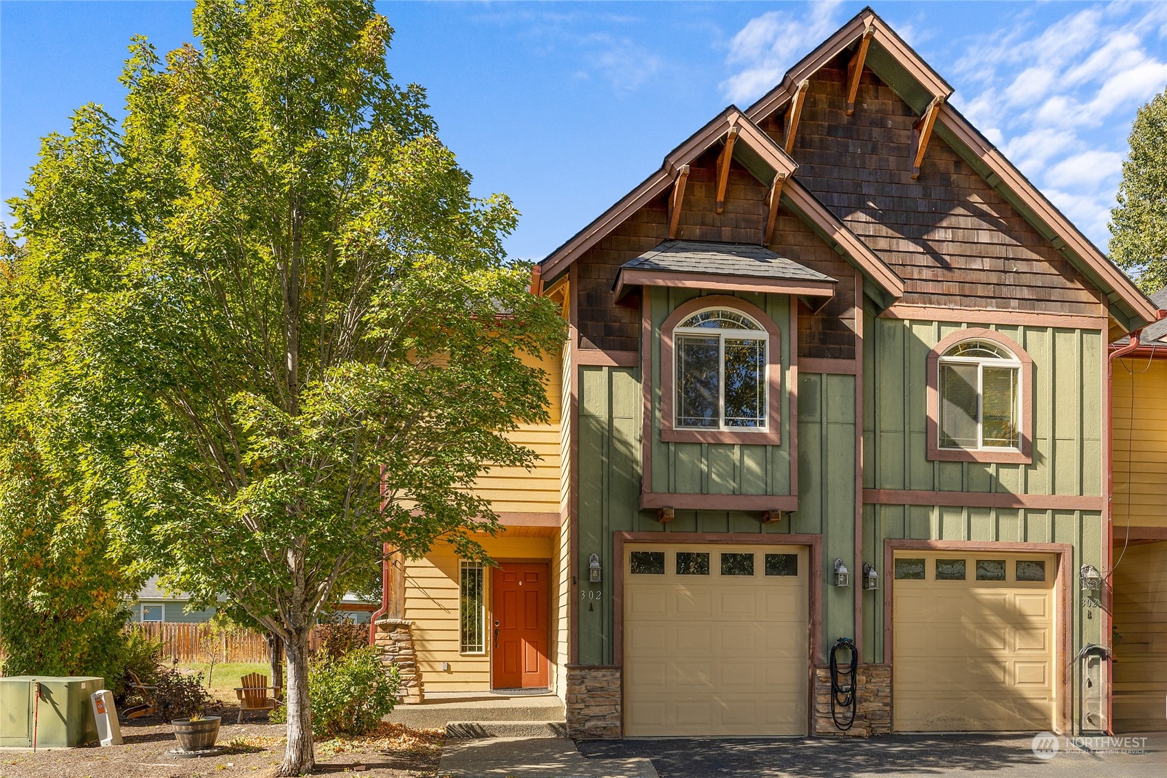 a front view of a house with a tree