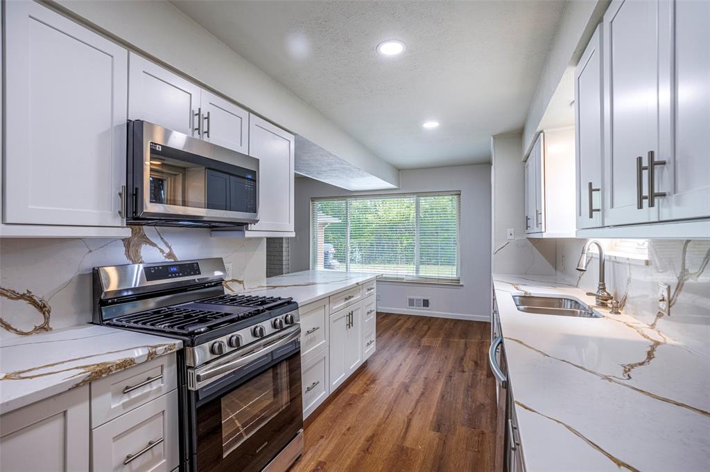 a kitchen with a stove a sink and a microwave