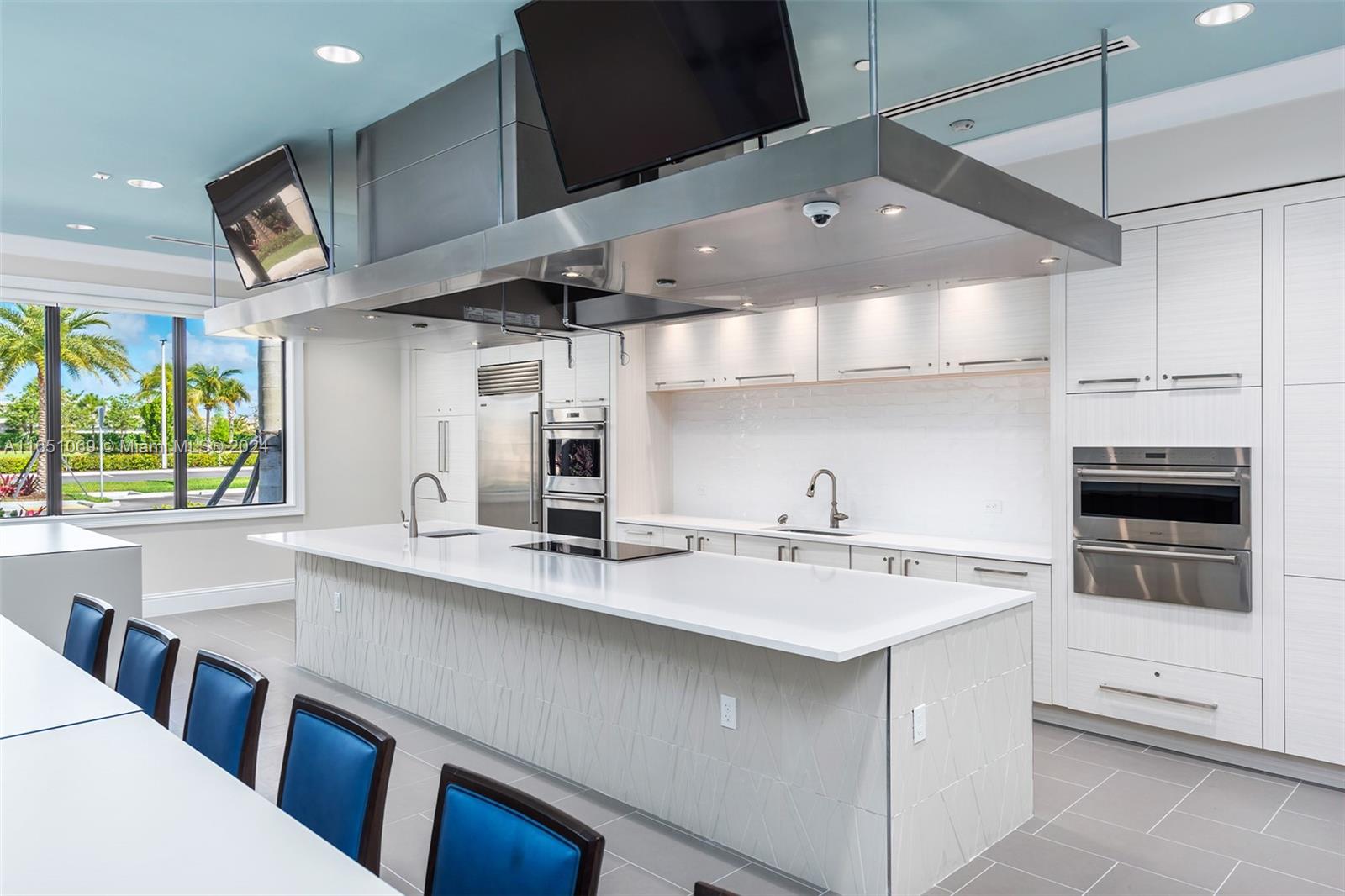 a kitchen with stainless steel appliances a sink a stove and a wooden floor