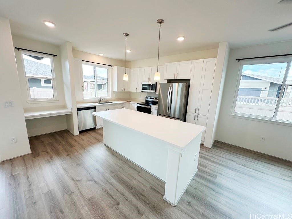 a large kitchen with a wooden floor and outdoor view