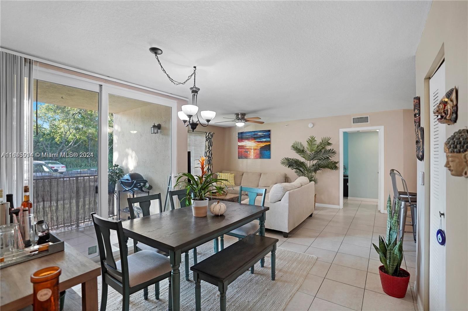 a dining room with furniture potted plants and wooden floor