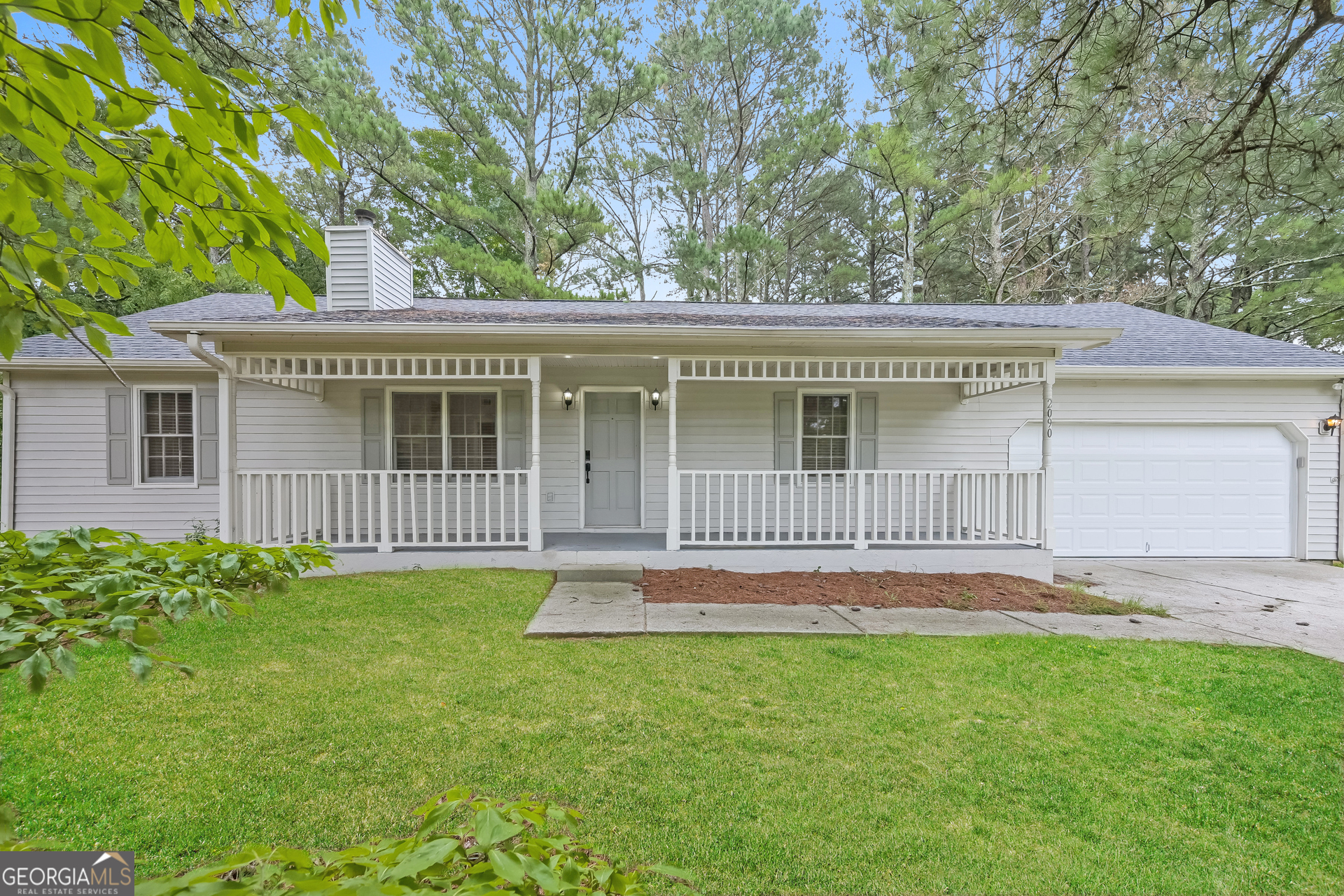 a front view of a house with a garden and yard