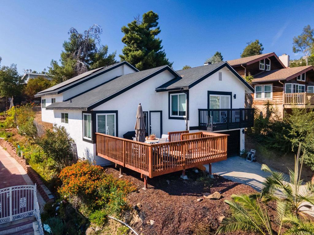 a view of a house with wooden deck and a garden