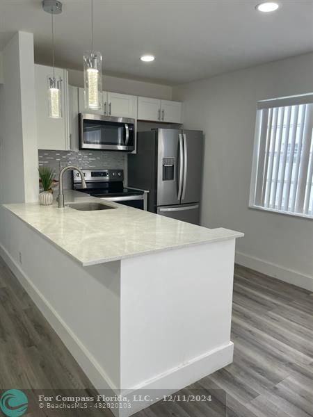 a kitchen with stainless steel appliances a microwave a sink and a refrigerator