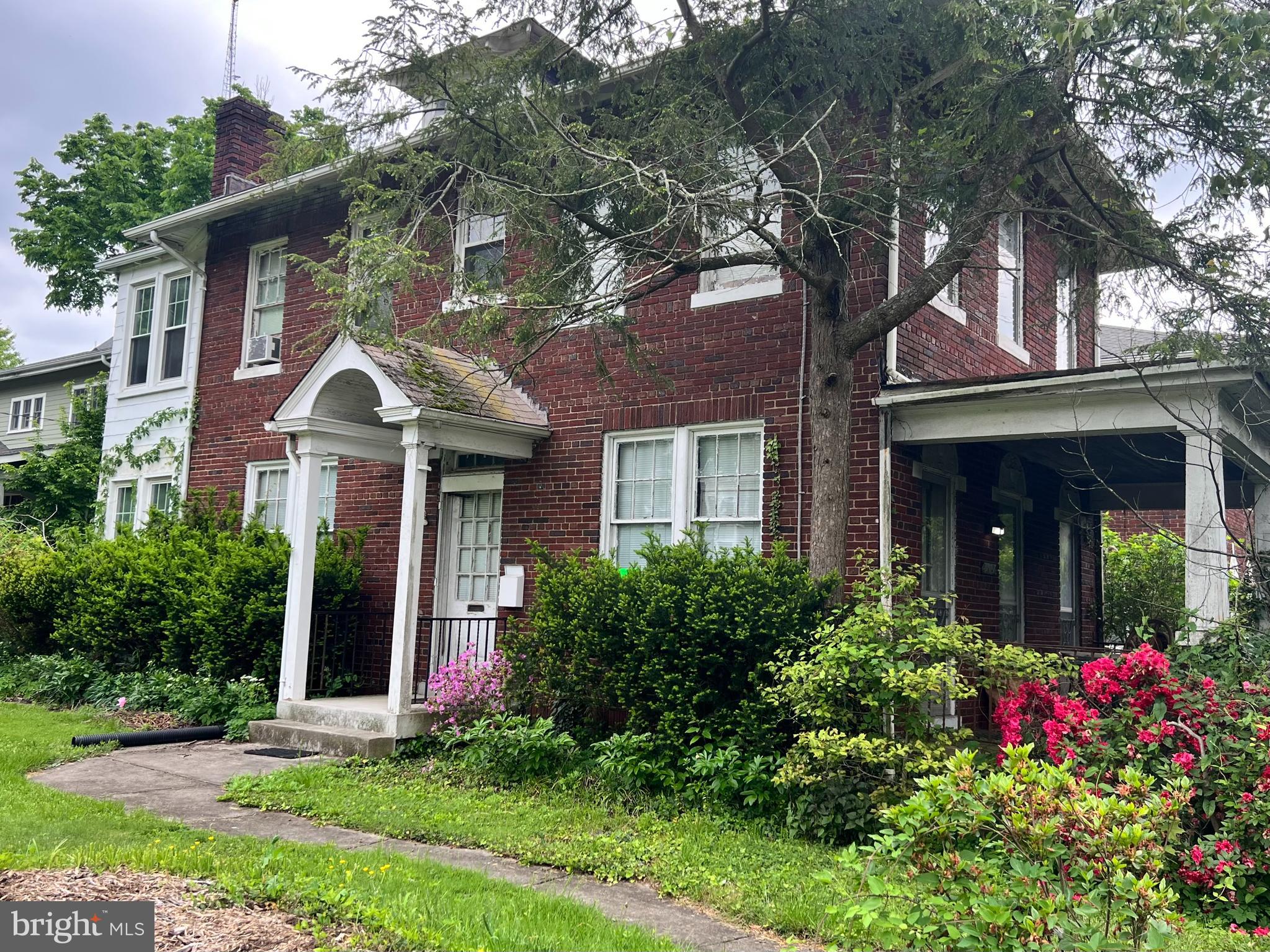 front view of a brick house with a yard