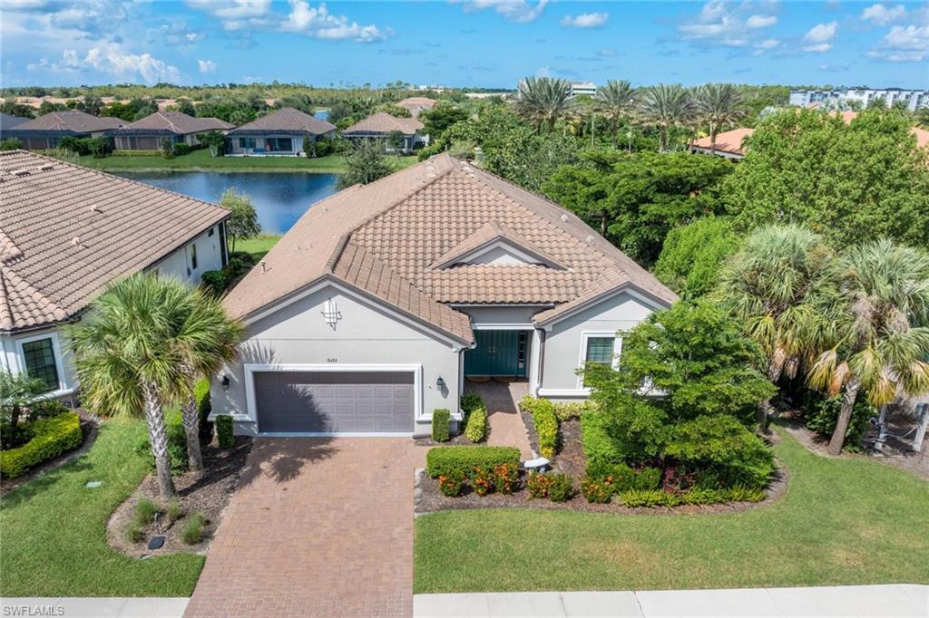 View of front facade featuring a water view, a front lawn, and a garage