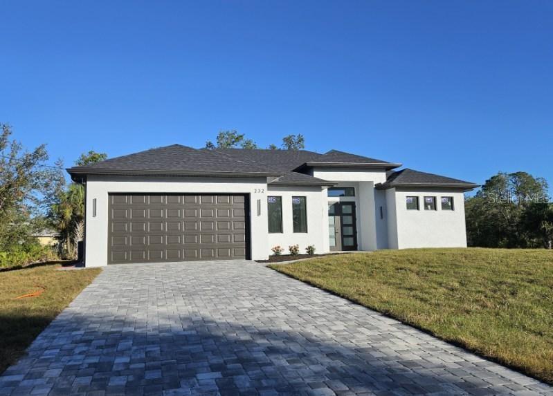 a front view of a house with a yard and garage