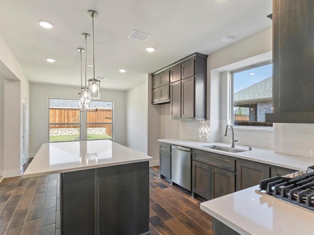 a kitchen with stainless steel appliances granite countertop a sink stove and wooden cabinets