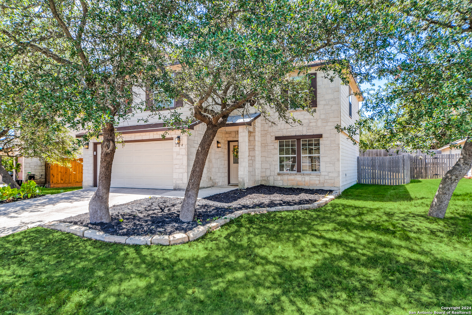 a view of a house with a yard and tree