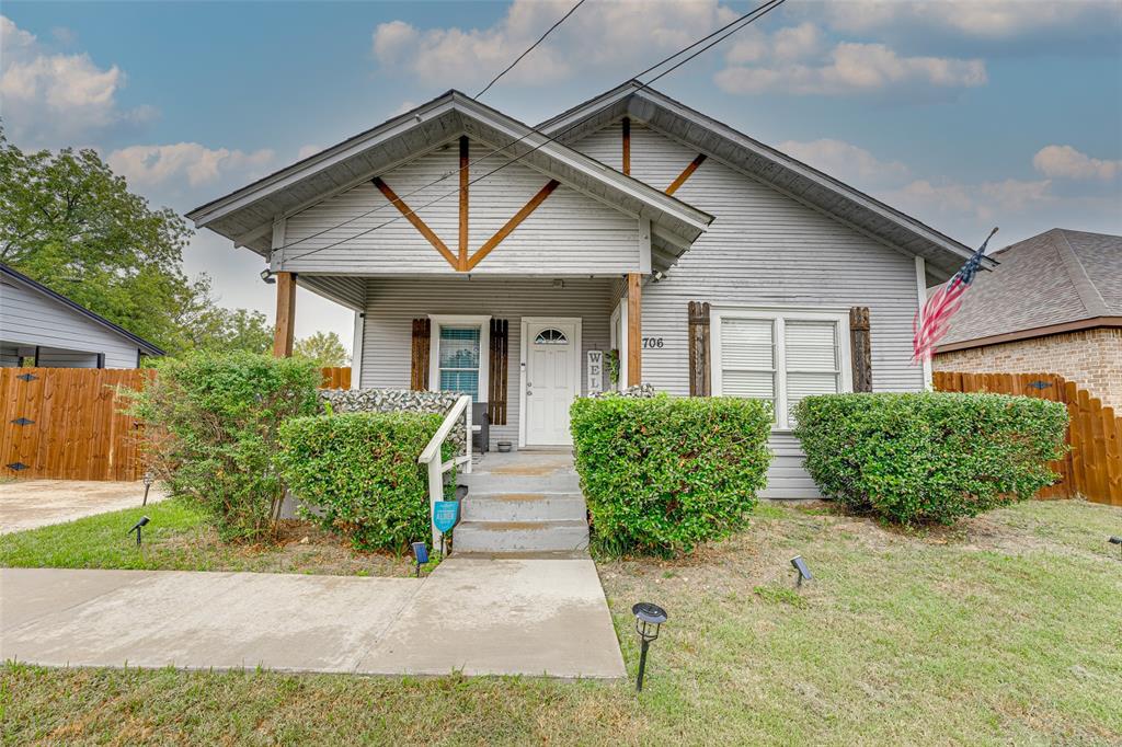 a front view of a house with a yard and potted plants