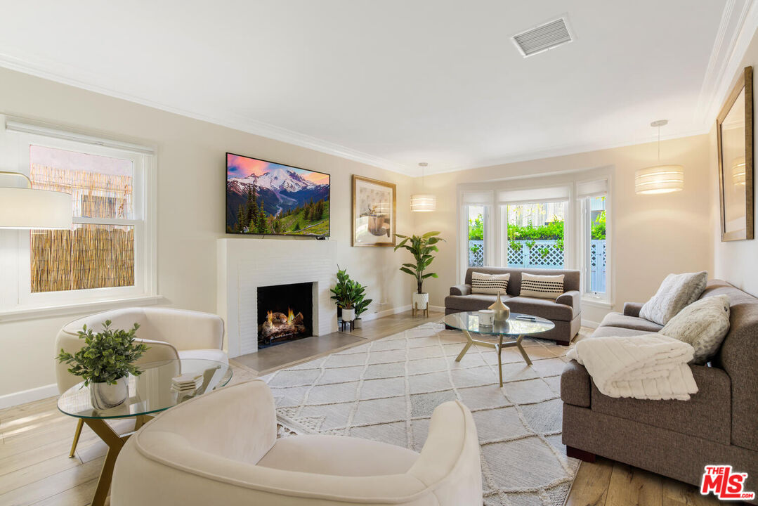 a living room with furniture a fireplace and a large window