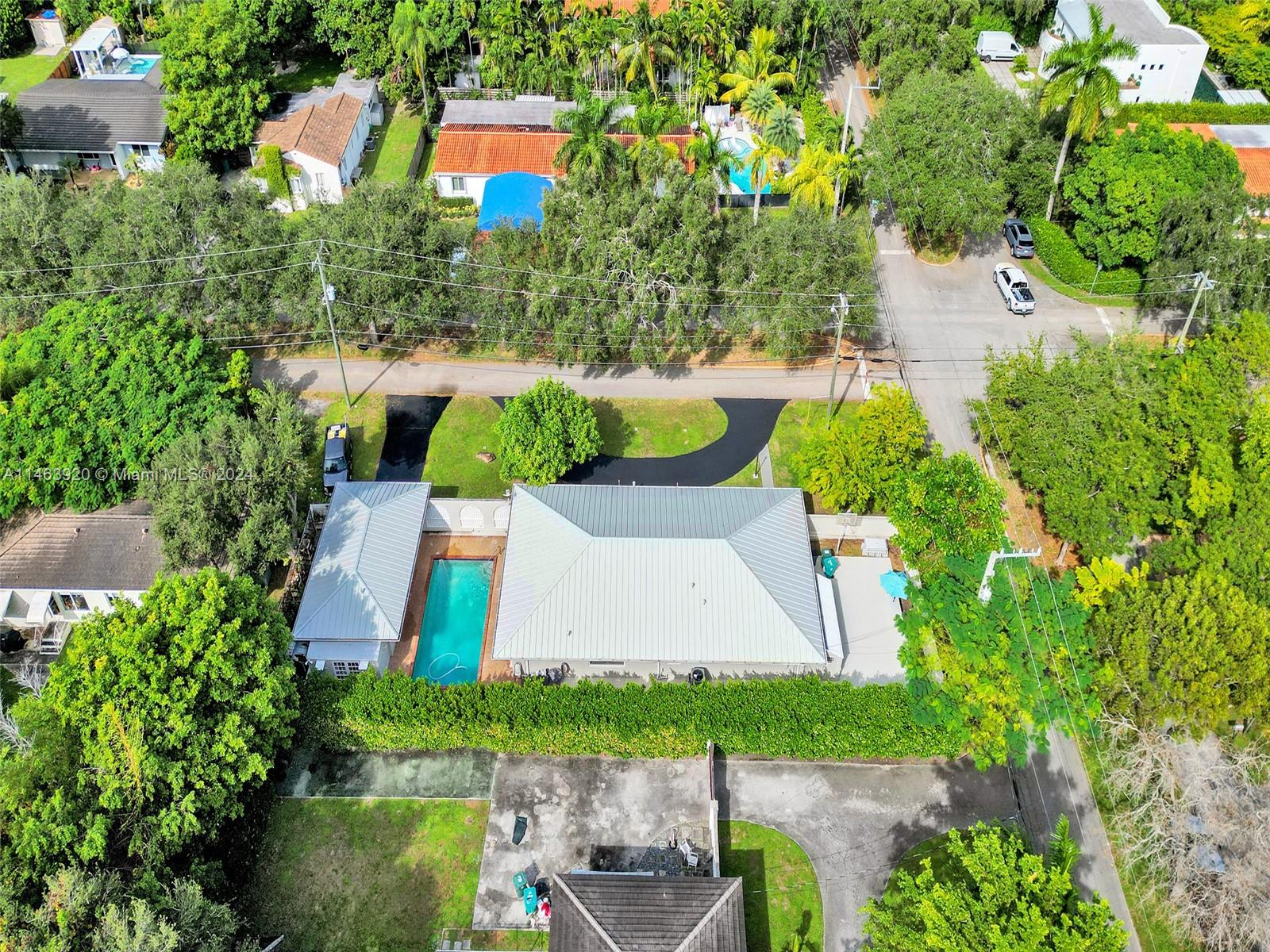 an aerial view of a house with a yard and a large pool