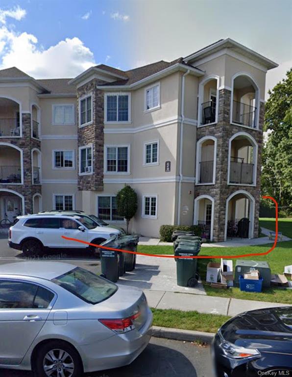 a front view of a building with cars parked