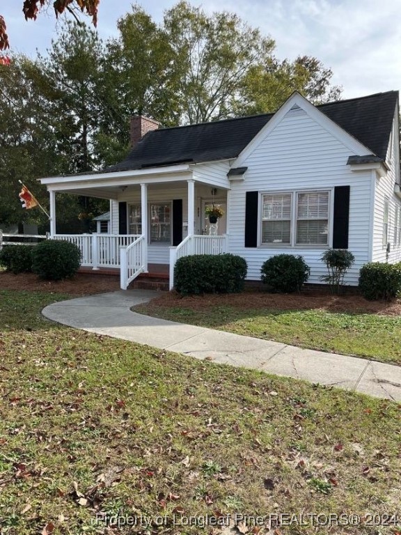 a front view of a house with a yard and trees