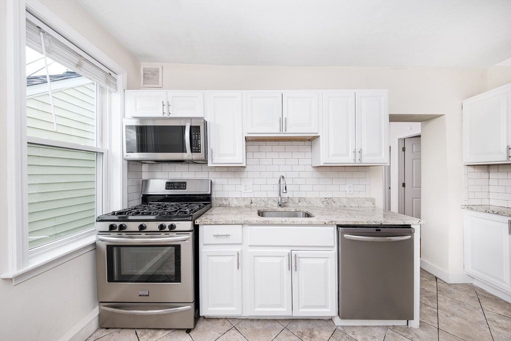 a kitchen with stainless steel appliances a stove sink microwave and cabinets