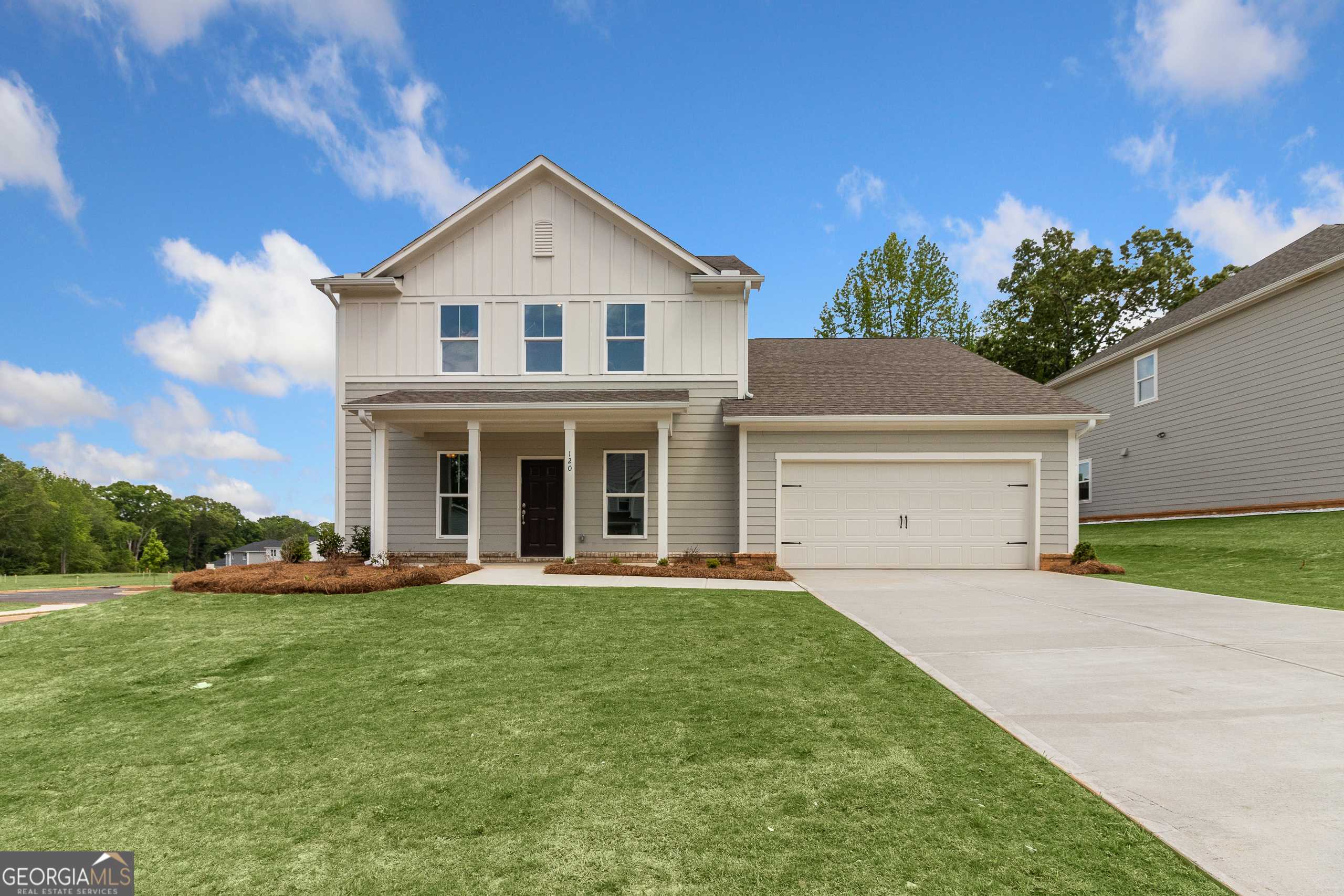 a front view of a house with a yard and trees