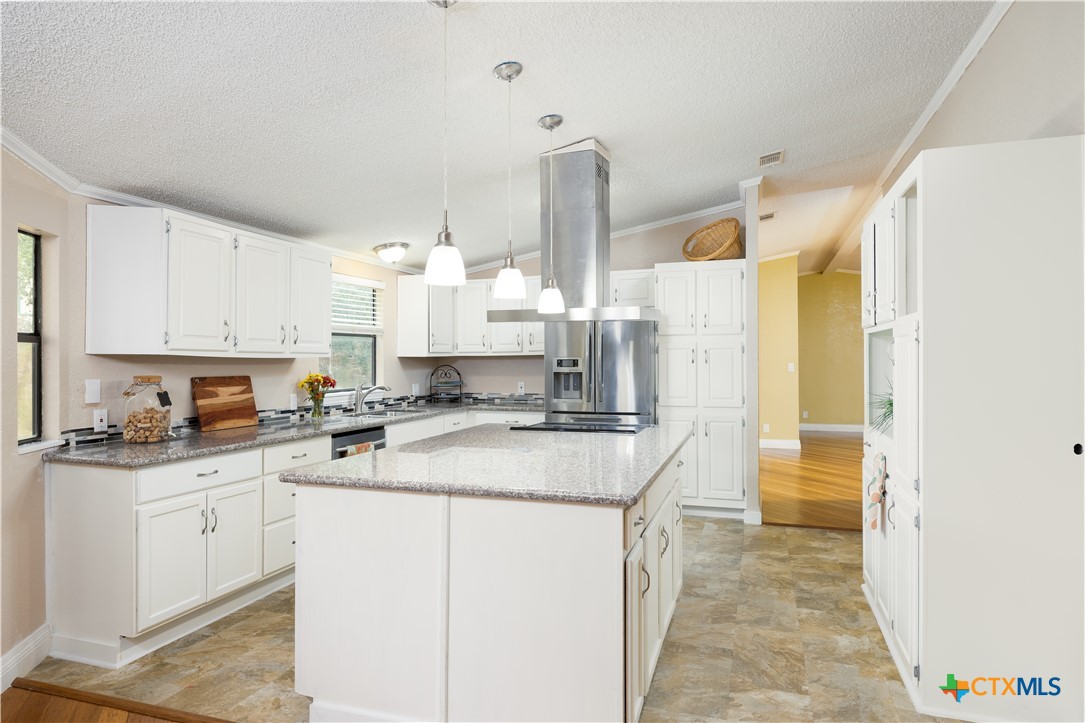 a kitchen with a sink a stove and cabinets