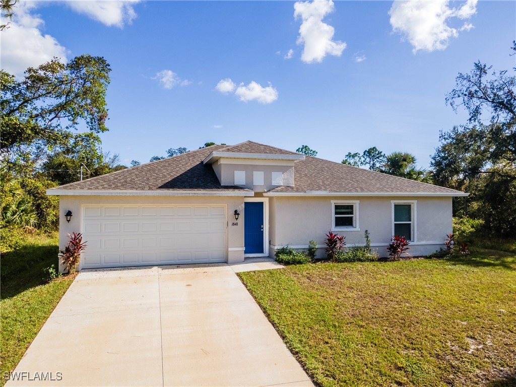 a front view of house with yard and trees around