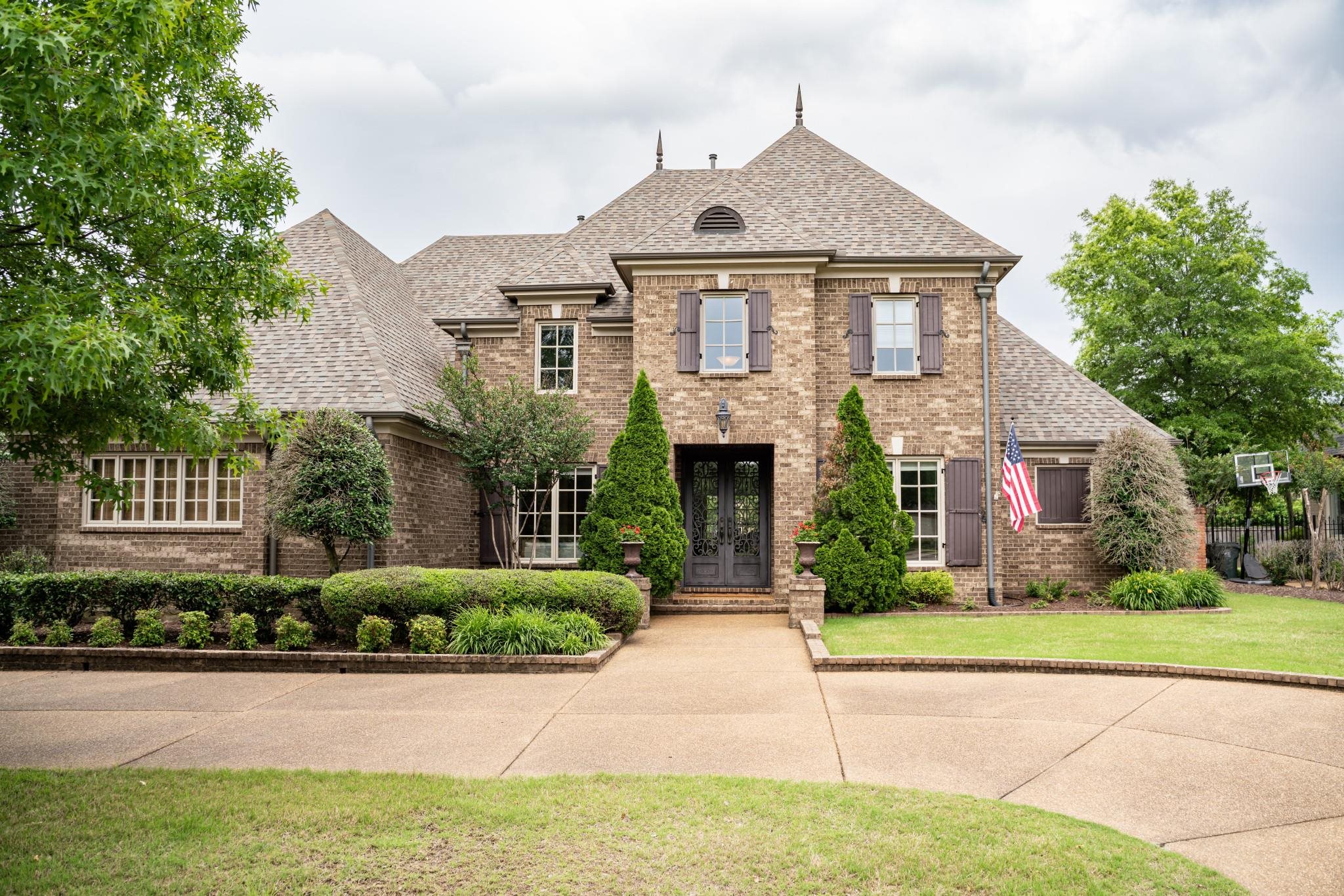 a front view of a house with a garden and plants